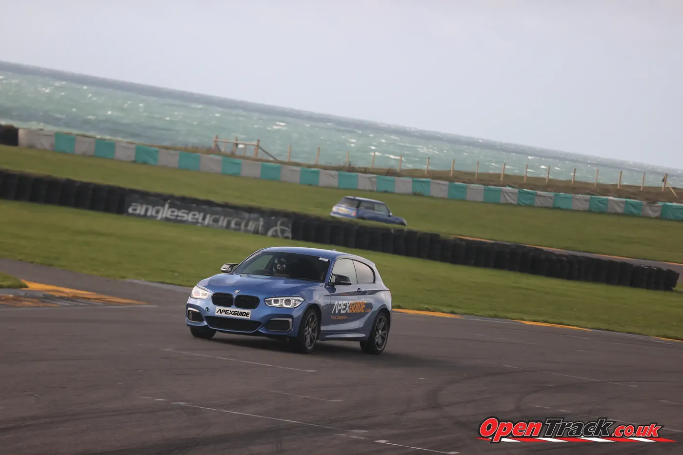 The ApexGuide BMW at Anglesey Circuit with the sea behind